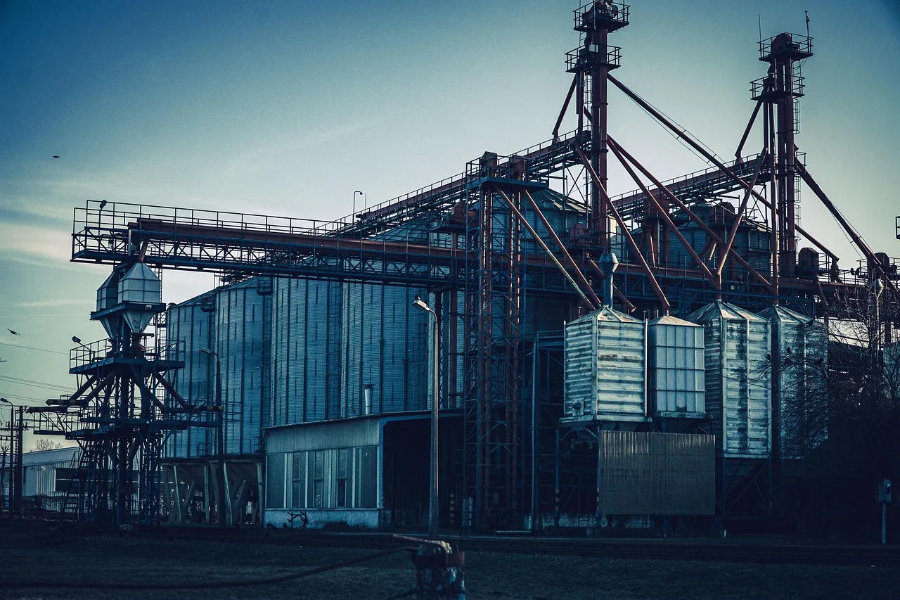 Industrial facility with storage silos and elevated structures.